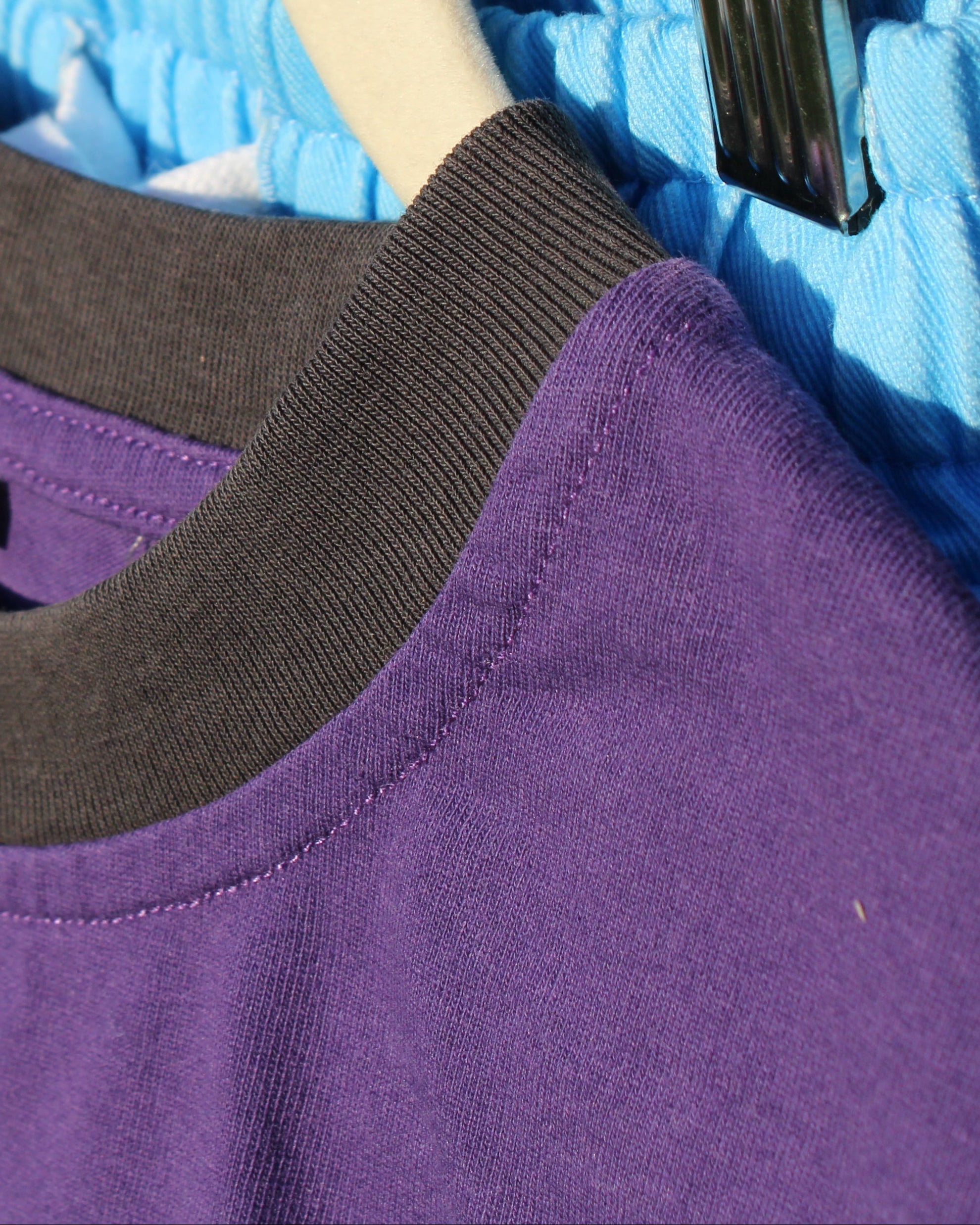 Purple shirt with black collar on a hanger