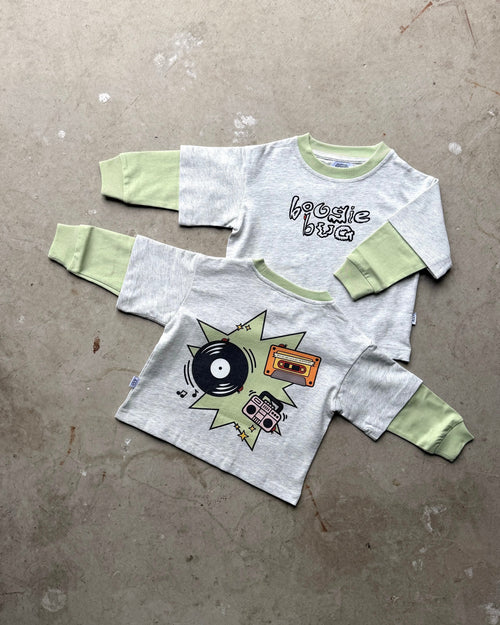 Children's long sleeve front  design that reads 'boogie bug' and back with graphic design on a concrete floor.
