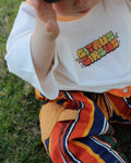 Citrus Circus Starburst OG Tee child with hands on face - oversized kids white tee with orange collar