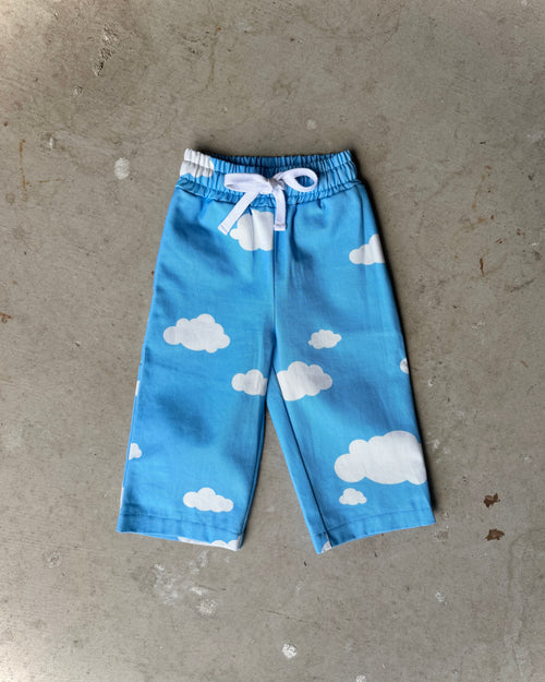 Blue pants with cloud pattern on a gray concrete surface