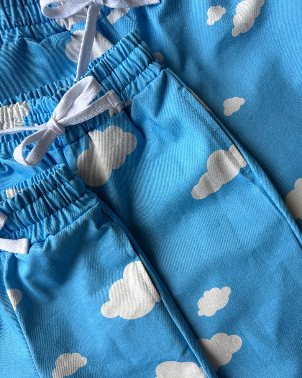Three pairs of blue pants with white cloud patterns.