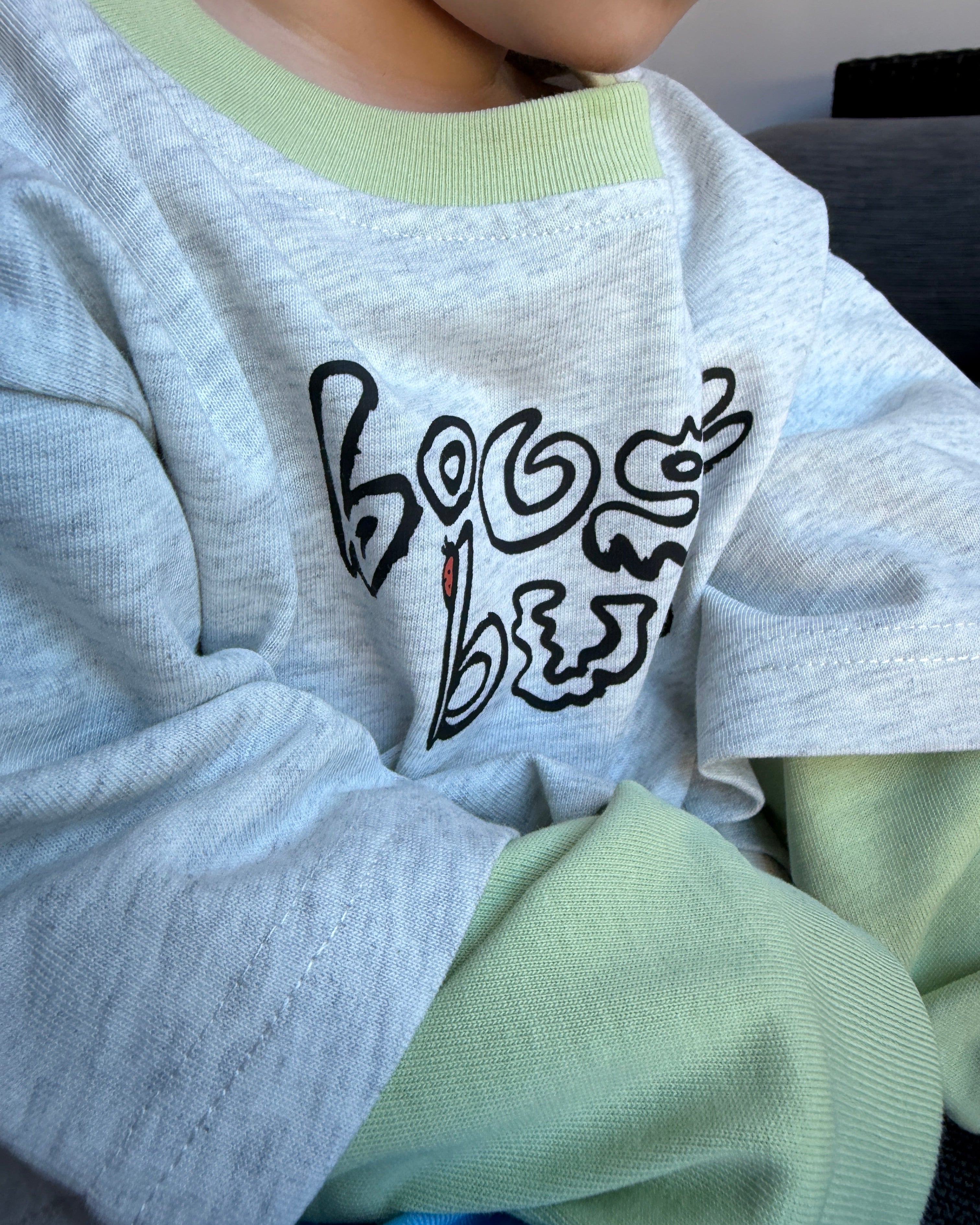 Light gray sweatshirt with black abstract design on a light green background